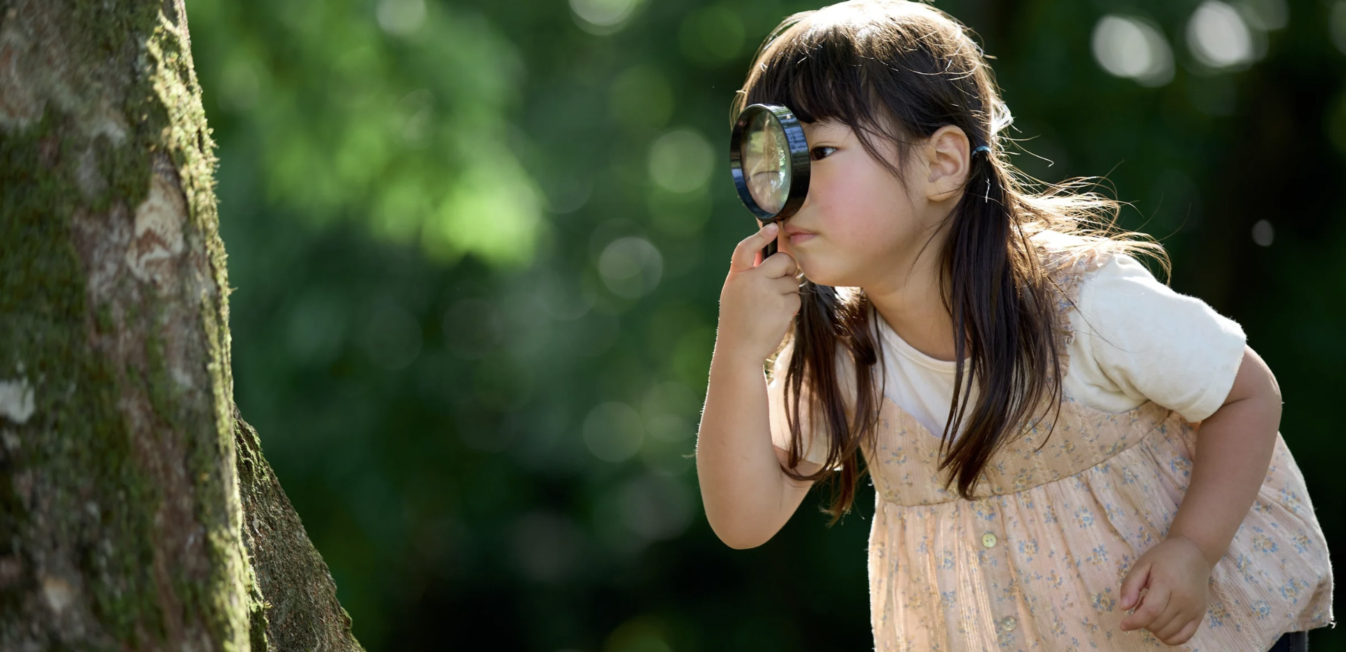 Child looking through a magnifying glass